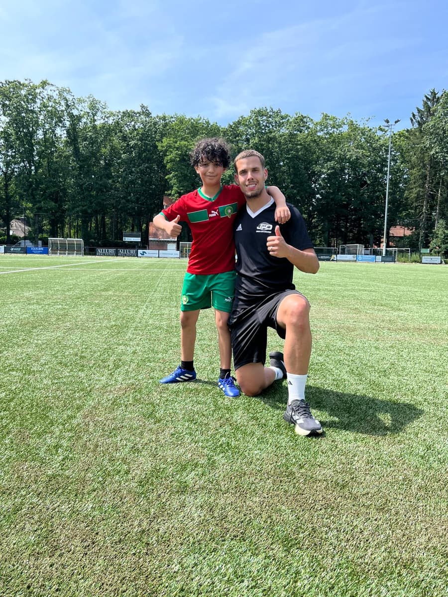 Jonge speler en coach op het veld tijdens een vakantiekamp van JPD